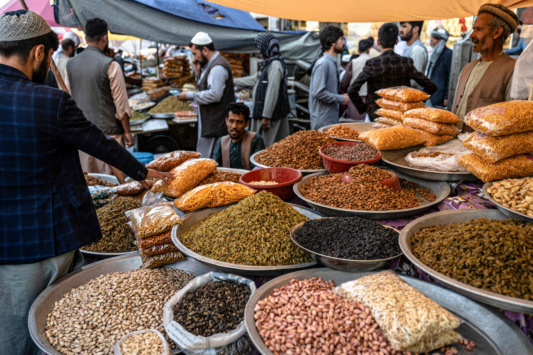 People buy dry fruits ahead of Eid al-Fitr which marks the end of the holy fasting month of Ramadan, at a market in Kabul on April 30, 2022. (Photo by Wakil KOHSAR / AFP)